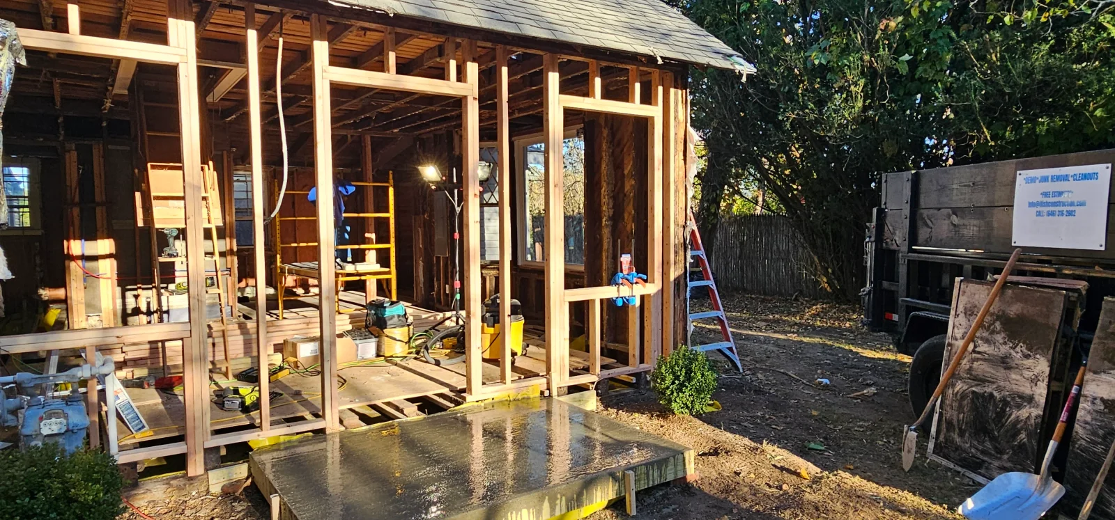 Wood-framed residential addition with studs, headers, and concrete foundation during construction phase
